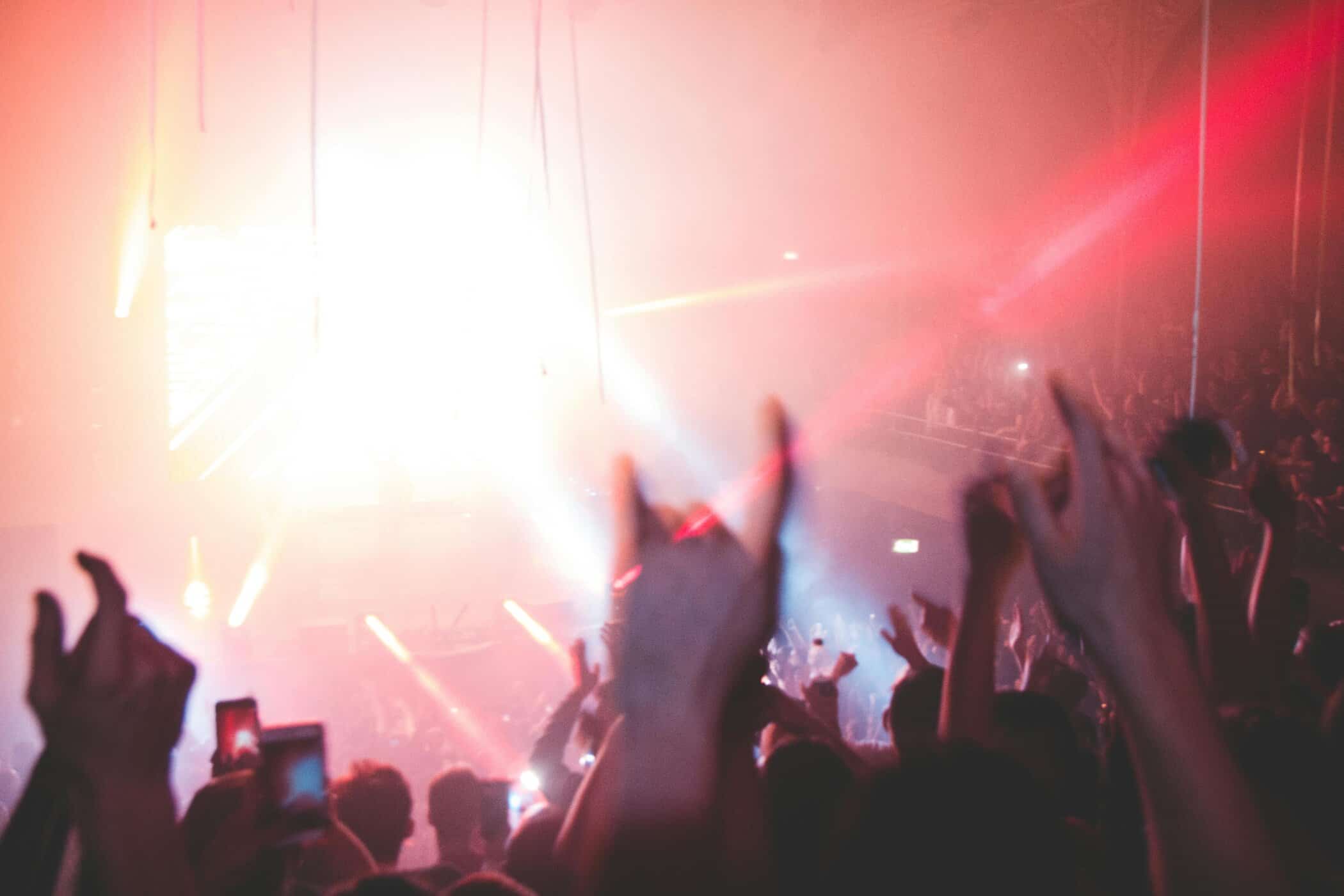 Hände von Menschenmenge vor Lichtern bei Konzert