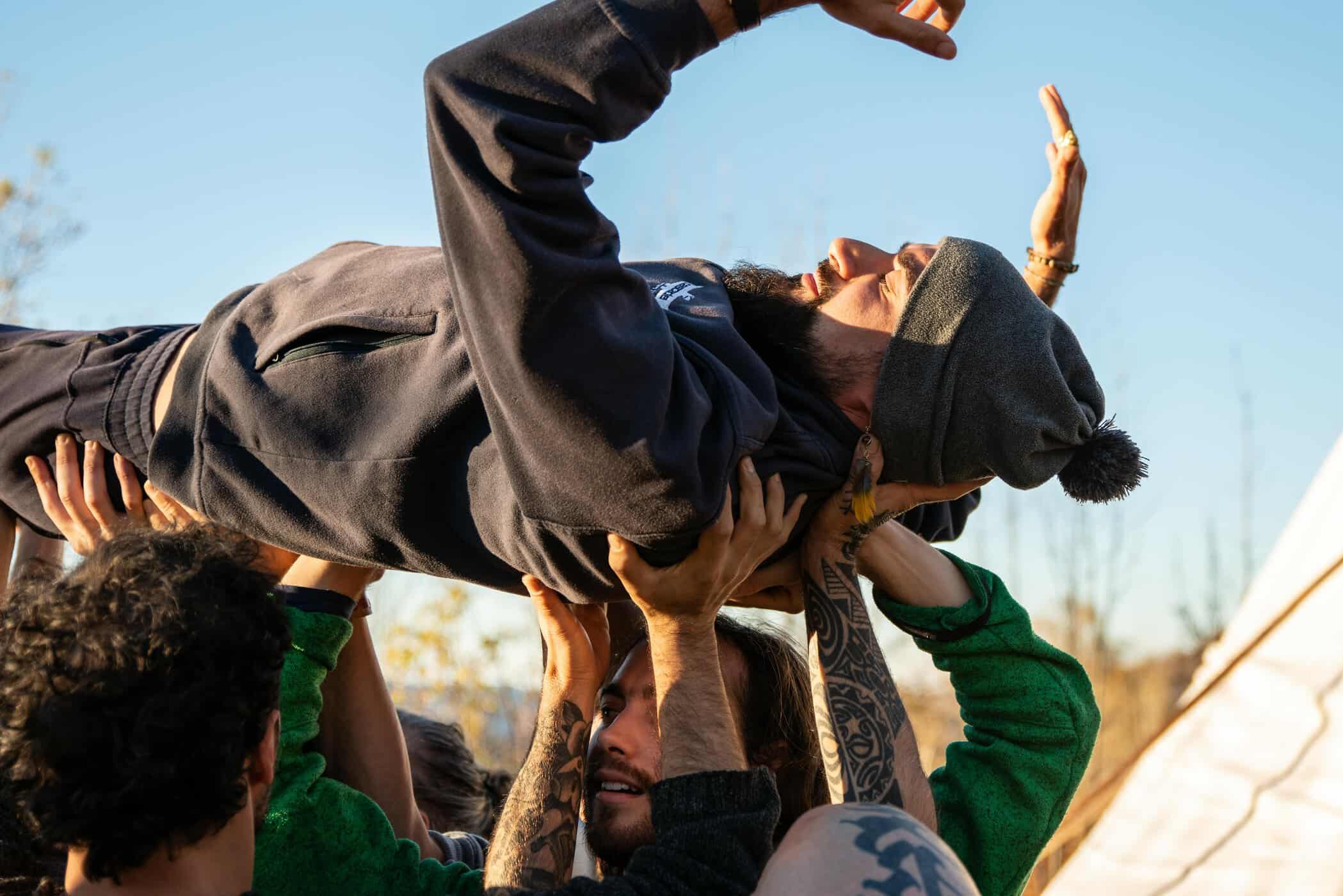 man gets carried by other hands