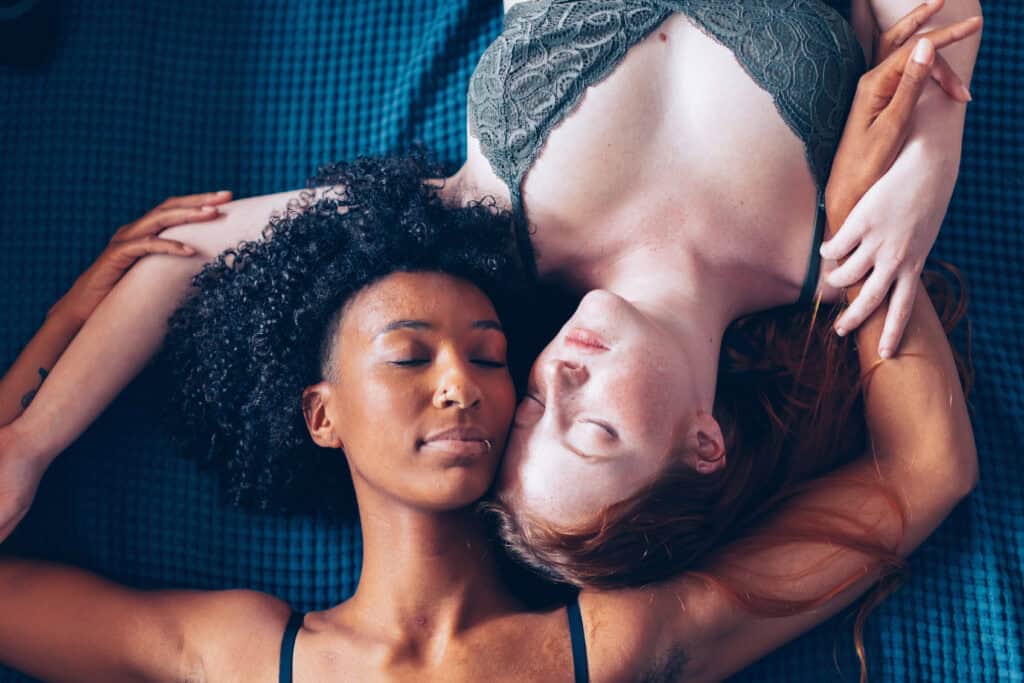 Zwei Frauen liegen entspannt nebeneinander auf einer blauen Decke – Symbolbild für ADHS und Sexualität, emotionale Nähe und Intimität bei Erwachsenen.