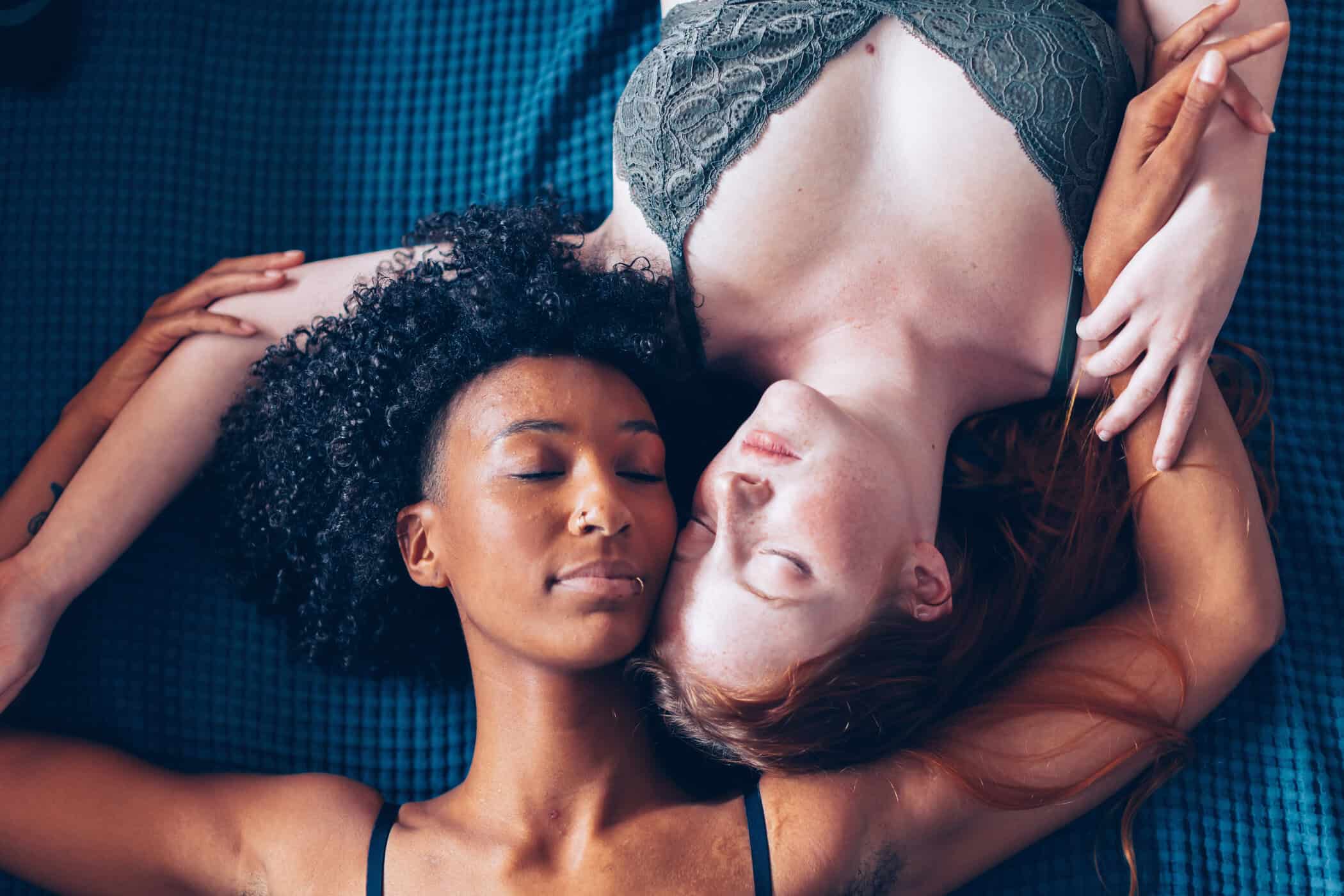 Zwei Frauen liegen entspannt nebeneinander auf einer blauen Decke – Symbolbild für ADHS und Sexualität, emotionale Nähe und Intimität bei Erwachsenen.