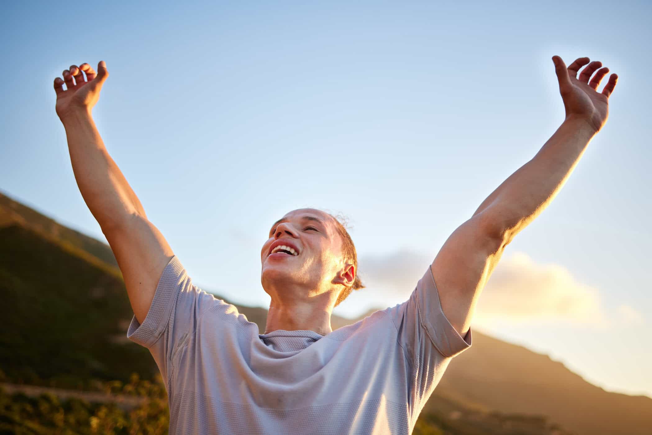 Mann streckt jubelnd die Arme in den Himmel – Symbolbild für Erleichterung im Umgang mit ADHS und Perfektionismus