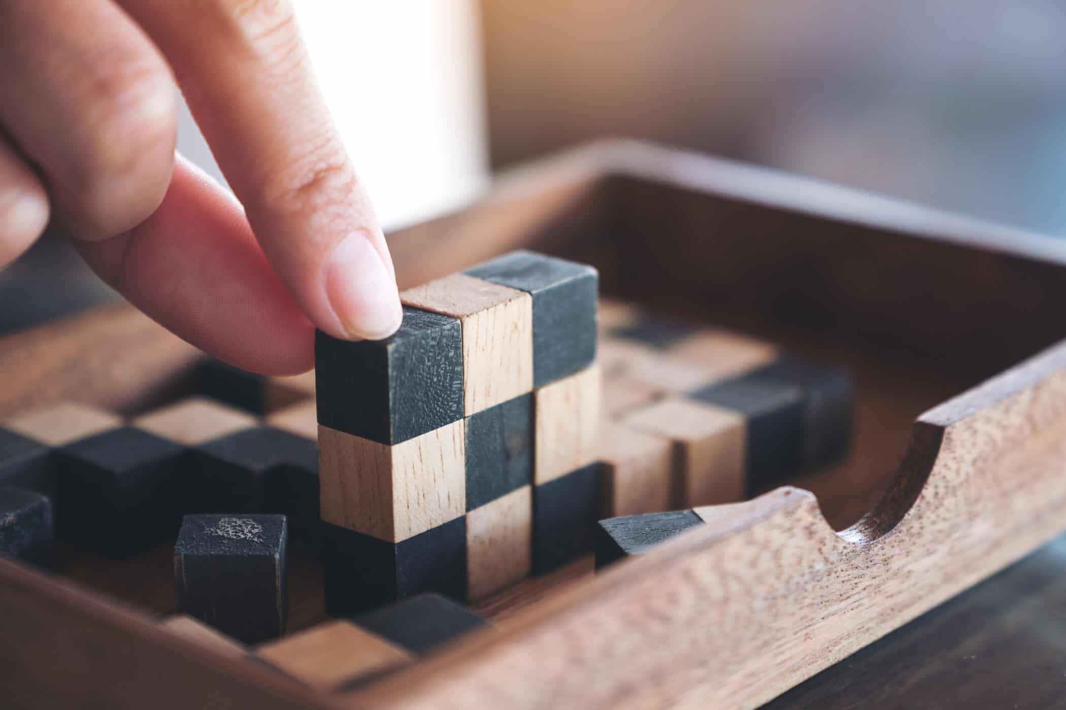 Hand halt Holzblock eines IQ-Test, symbolisiert Autismus Intelligenz
