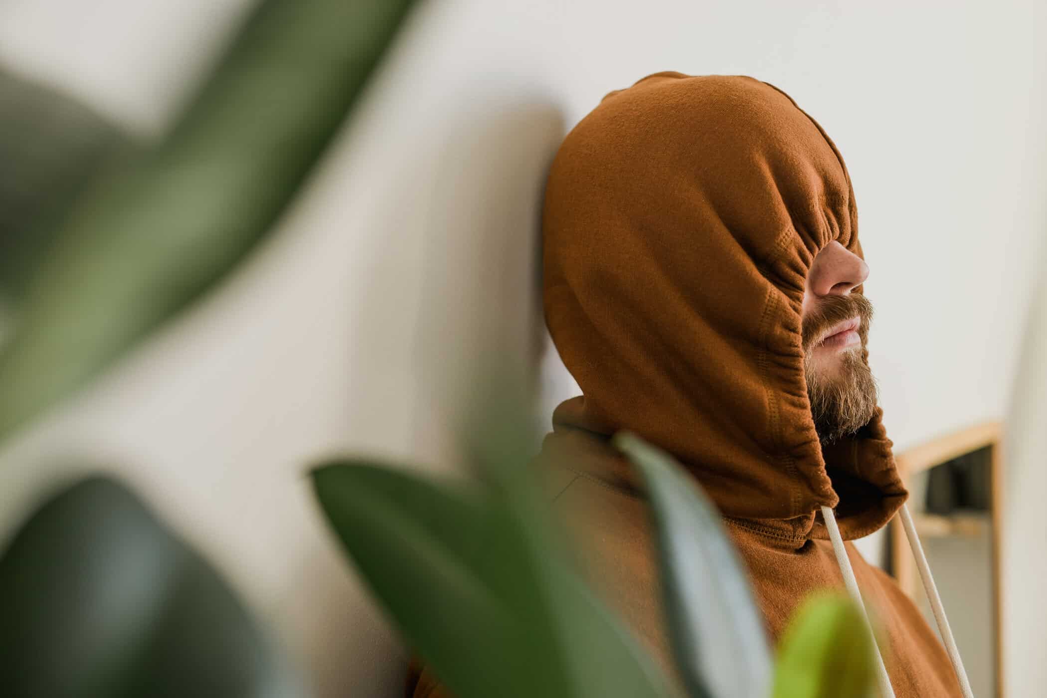 Mann verdeckt sein Gesicht mit seiner Kapuze, symbolisiert Masking Autismus