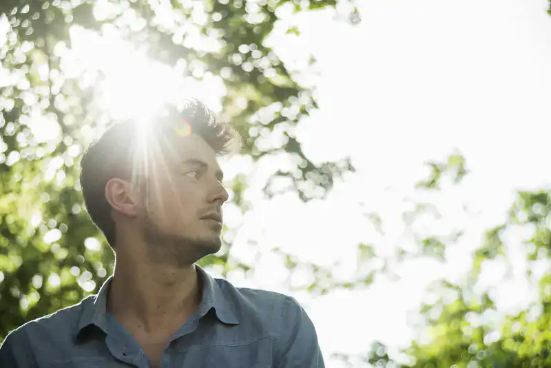 Mann mit Sonne im Hintergrund